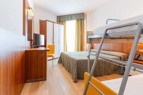 ein Hotelzimmer mit Etagenbett und Fernseher in der Unterkunft Hotel Touring in Caorle