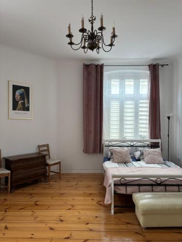 a bedroom with a bed and a window with a chandelier at Na skraju Rynku 110 m2 in Tarnowskie Góry