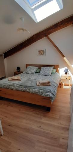 a bedroom with a large bed in a attic at Gîte Le Fenil in Allondrelle-la-Malmaison