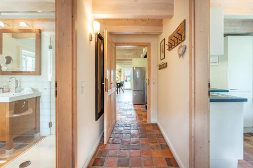 a hallway leading to a kitchen with a tile floor at Ferienhaus Hyggehüs in Risum-Lindholm
