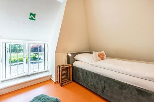 a small room with a bed and a window at Ferienhaus Hyggehüs in Risum-Lindholm