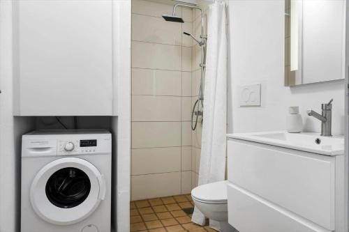 a bathroom with a washing machine and a sink at 0407-Romo-Vestergade-225-App-9 in Høm