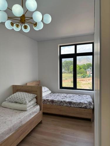a bedroom with two beds and a window at Парус in Cholpon-Ata