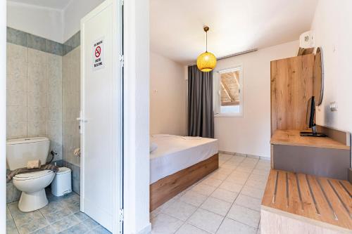 a bathroom with a bed and a toilet at Haris Hotel by Diomedes Group in Hanioti