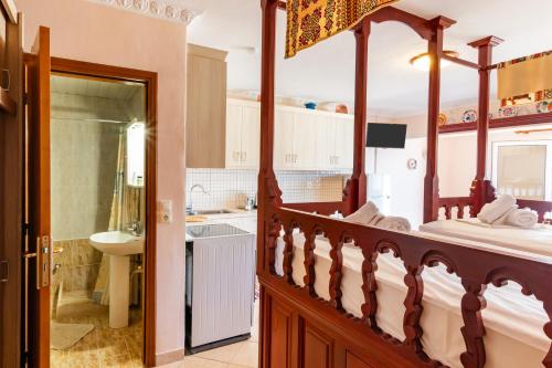a bedroom with a large canopy bed and a bathroom at Maria's Studio 1 in Karpathos