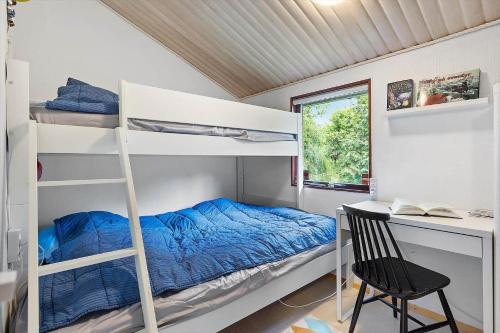 a bedroom with bunk beds and a desk and a chair at FJ1200-Jaegerspris-Planetvej-8 in Jægerspris