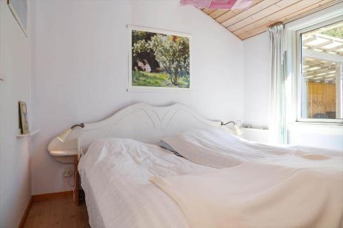 a white bed in a bedroom with a picture on the wall at 13374-1-Vig-Thorsvej-4 in Vig