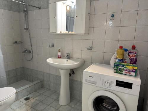 ein Badezimmer mit Waschmaschine und Waschbecken in der Unterkunft Konstantinos in Gythio