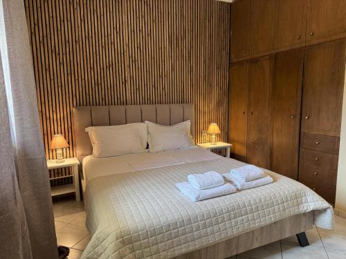 ein Schlafzimmer mit einem Bett, auf dem zwei Handtücher liegen in der Unterkunft Konstantinos in Gythio