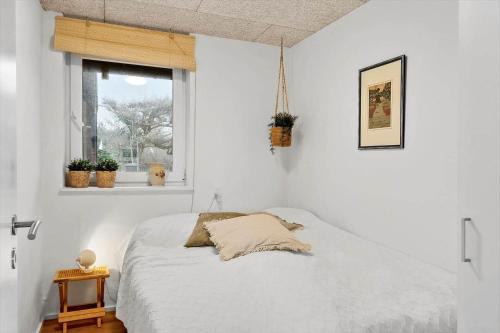 a white bedroom with a bed and a window at LF12715-Vinderup-Vibevej-15 in Ejsingholm
