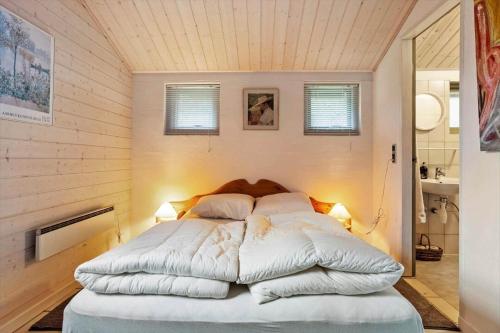 a bedroom with a large bed with white sheets and pillows at LF14348-Roslev-Harrebjergvej-48 in Harre