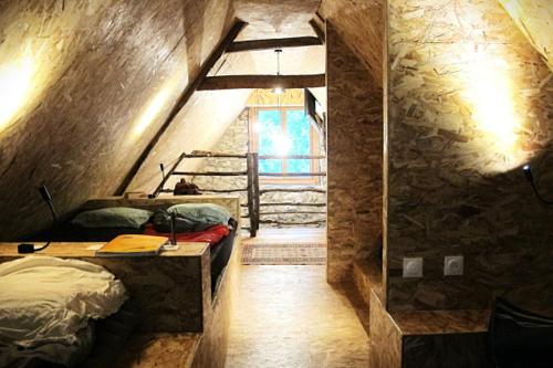 a bedroom with a bed and a staircase in a room at Cabane du Serris - Expérience insolite dans les Pyrénées in Beaudéan