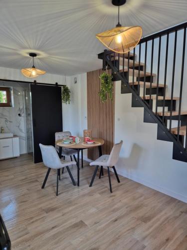 a dining room with a table and chairs and a staircase at Apartament Królówka in Nowy Wiśnicz