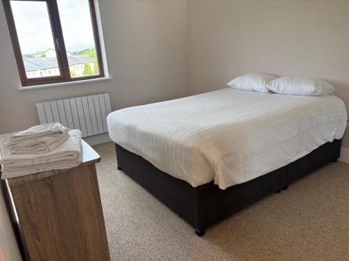 a bedroom with a large bed with white sheets and pillows at Lidia House in Westport