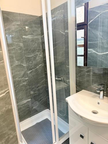 a bathroom with a shower and a sink at Beni Apartman in Szeged