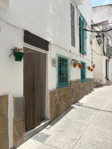 a white building with green windows and a door at Las Casitas de mi Abuela in Casares