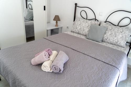 a bedroom with a bed with towels on it at Rodostagma 2 in Rodholívos