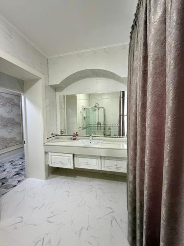 a bathroom with a sink and a large mirror at Mirali Resort in Almaty