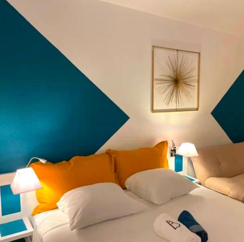 a room with a couch and a bed with orange pillows at Studio Calm Blue in Le Diamant