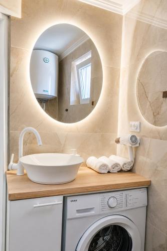 a bathroom with a sink and a washing machine at Danube Panorama House - River View, Jacuzzi & Nature in Čelarevo