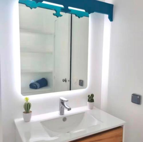 a bathroom with a sink and a mirror at Studio Calm Blue in Le Diamant