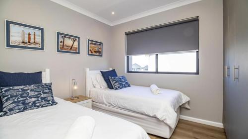 a bedroom with two beds and a window at My Plett, Your Plett in Plettenberg Bay