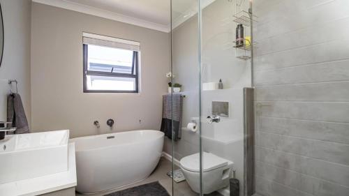 a bathroom with a tub and a toilet and a sink at My Plett, Your Plett in Plettenberg Bay