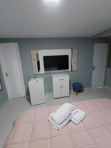 a bedroom with a tv and two towels on the floor at Pousada Por do Sol in Lapa