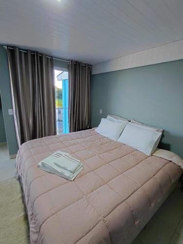 a bedroom with a large bed with a tray on it at Pousada Por do Sol in Lapa