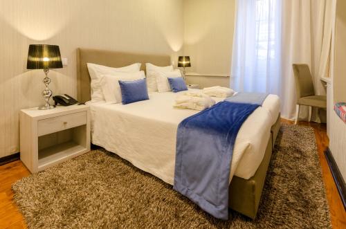 a bedroom with a large bed with blue and white pillows at Hotel INN Rossio in Lisbon
