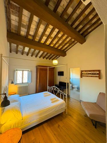 a bedroom with a large bed and a couch at Le 3 Rane B&B in Treggiaia