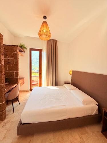 a bedroom with a bed and a desk and a lamp at Putechella Slow Living Retrait in Tramonti