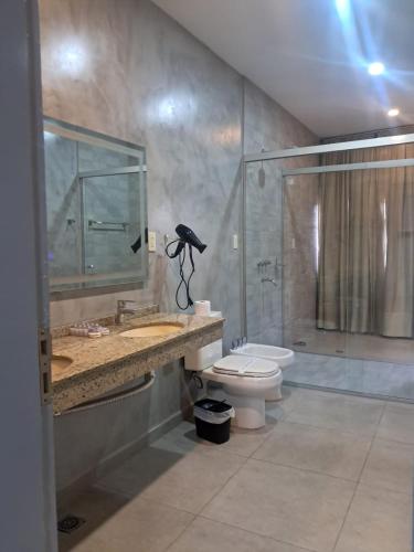 ein Badezimmer mit Dusche, Toilette und Waschbecken in der Unterkunft Luxsur in Encarnación