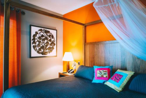 a bedroom with a blue bed with a canopy at Hotel Montana in Petionville