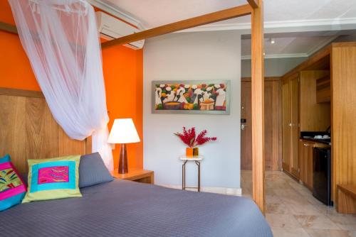 a bedroom with a blue bed and an orange wall at Hotel Montana in Petionville