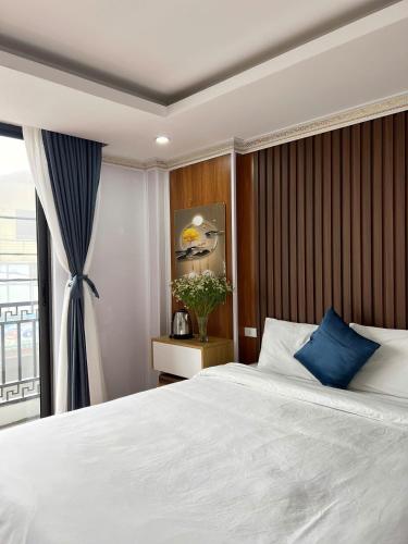 a bedroom with a large white bed and a window at Sa Pa Camellia Hotel in Sapa