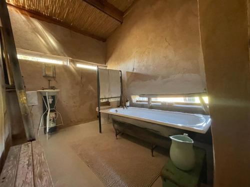 a large bathroom with a tub and a sink at Strooi Kooi - Unique Strawbale Cottage in Calitzdorp