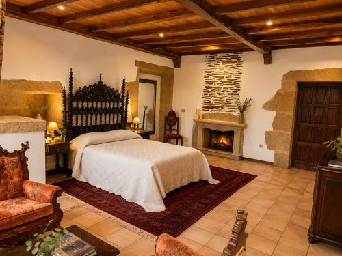 a bedroom with a bed and a fireplace at Hotel Pazo Do Souto in Carballo