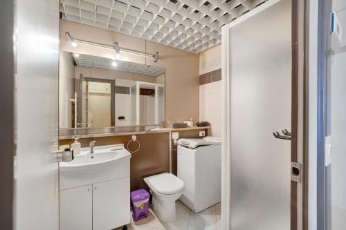 a bathroom with a sink and a toilet and a mirror at Appartamento Vista Lago Ghiffa in Ghiffa