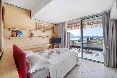 a bedroom with a bed and a large window at Appartamento Vista Lago Ghiffa in Ghiffa