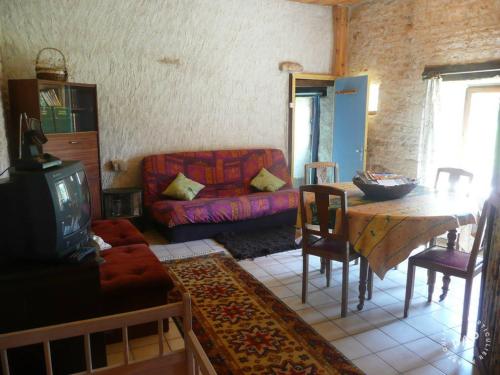 a living room with a couch and a table at Gite de la Maison Noble in Champagné-le-Sec