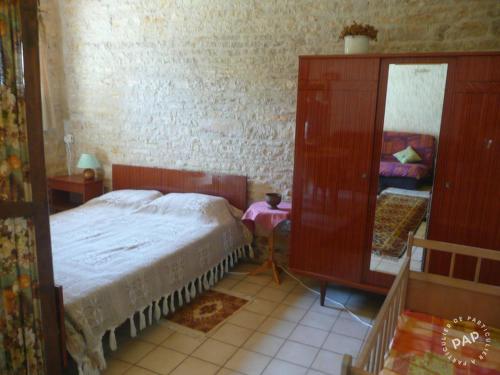 a bedroom with a bed and a dresser and a mirror at Gite de la Maison Noble in Champagné-le-Sec