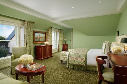 a hotel room with a bed and a table at The Lanesborough, Oetker Hotels in London