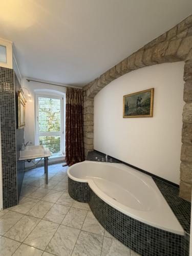 a bathroom with a large tub and a sink at Apartmenthaus Albrechtsburg in Bad Schandau