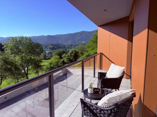 a balcony with two chairs and a table at Vila Katarina - Lake View Apartments in Bled
