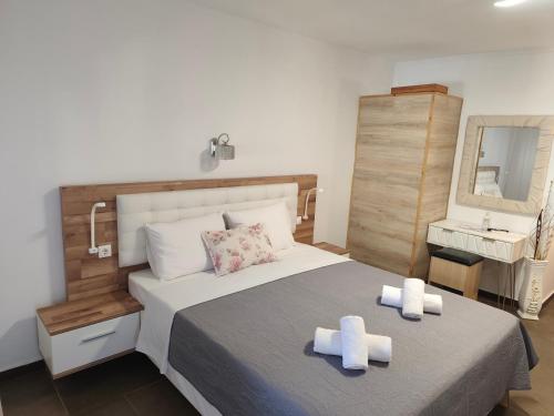 a bedroom with a bed with two white towels on it at Hotel Alexandros II in Toroni