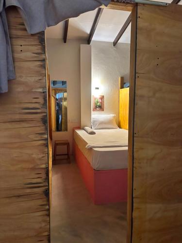 a small room with a bed and a closet at AAA Happy Hostel in Arugam Bay