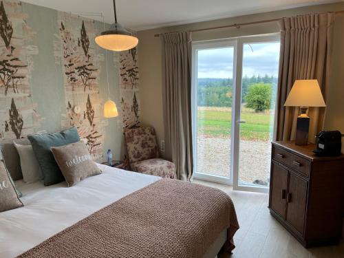 a bedroom with a bed and a large window at La Villa du Pré Du Cerf---------- TARIF PREFERENTIEL 2 NUITS------- in Spa