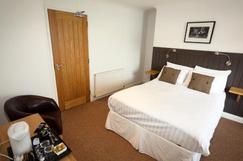 a hotel room with a bed and a desk with a camera at The Arch Inn in Ullapool