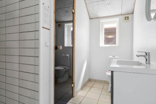 a bathroom with a toilet and a sink at 2002-Romo-Juvrevej-51b in Høm